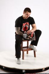 Alex Sitting With Pistol Pose